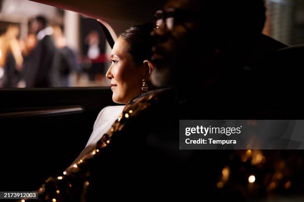 the female role actress looks out the car window, her expression showing anxiety and expectation. - premiere stock pictures, royalty-free photos & images