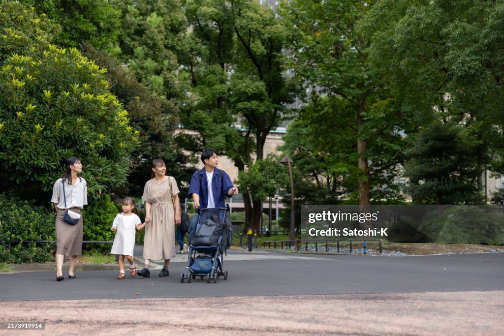 Family walking in public park in city