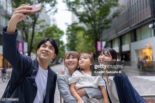 family taking selfie pictures on city street - k street stock pictures, royalty-free photos & images