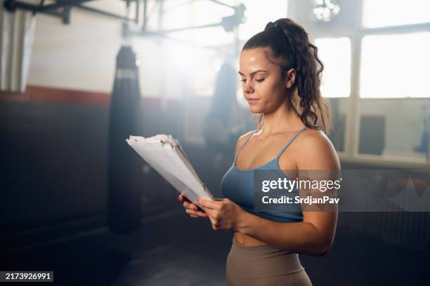 female caucasian kickboxer planning her training in the gym - white boxer briefs stock pictures, royalty-free photos & images
