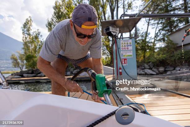 refueling a boat at the scenic lakeside marina for a day on the water - recreational boat stock pictures, royalty-free photos & images