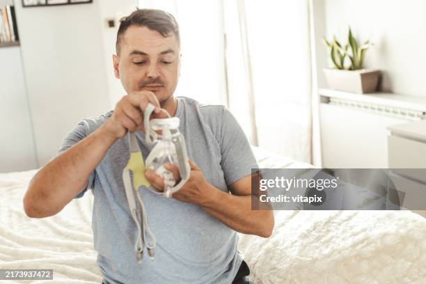 man wearing cpap machine for sleep apnea - cpap machine stock pictures, royalty-free photos & images