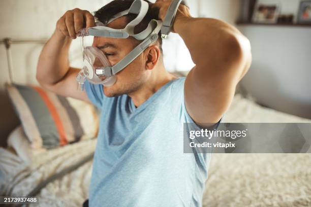 man wearing cpap machine for sleep apnea - cpap machine stock pictures, royalty-free photos & images