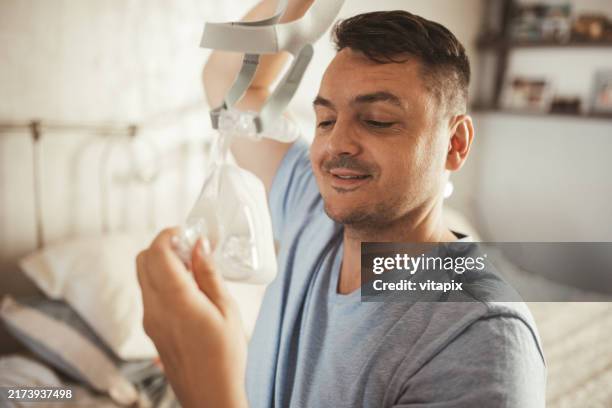 man wearing cpap machine for sleep apnea - cpap machine stock pictures, royalty-free photos & images