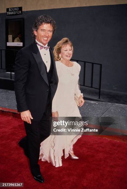 American actor Patrick Duffy, wearing a tuxedo and bow tie, and his wife, Americam ballet dancer Carlyn Rosser, who wears a white evening gown,...