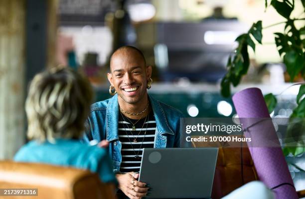 cheerful non binary business person smiling at woman, yoga mat nearby - guidance stock pictures, royalty-free photos & images
