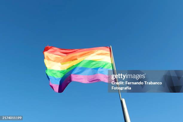 lgbt flag on sky blue background - drapeau arc en ciel photos et images de collection