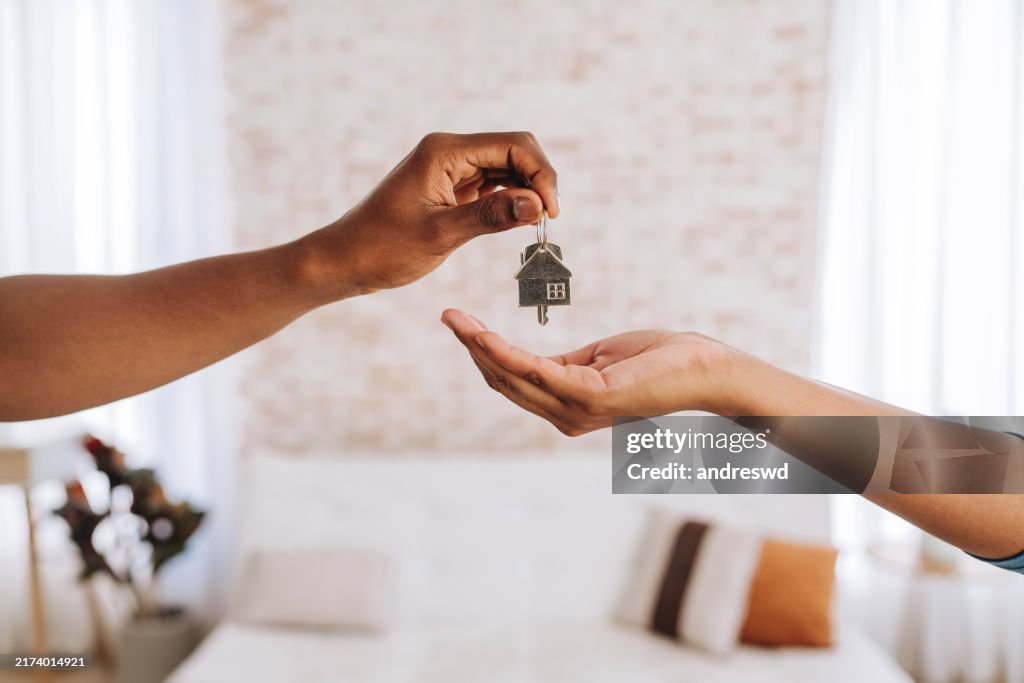 Immobilienmakler gibt einem Mann die Schlüssel zu seinem neuen Zuhause