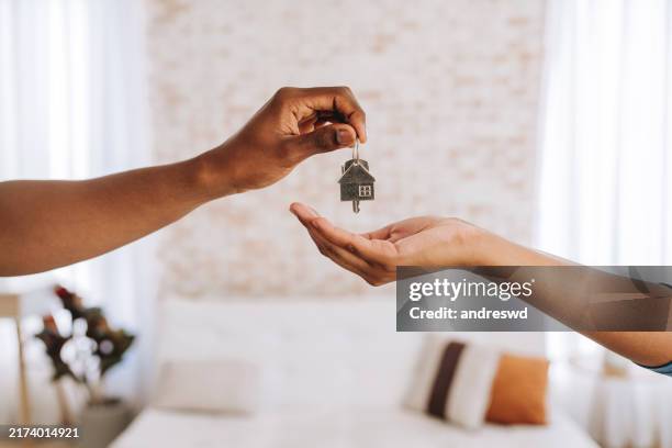 immobilienmakler gibt einem mann die schlüssel zu seinem neuen zuhause - wohnung stock-fotos und bilder