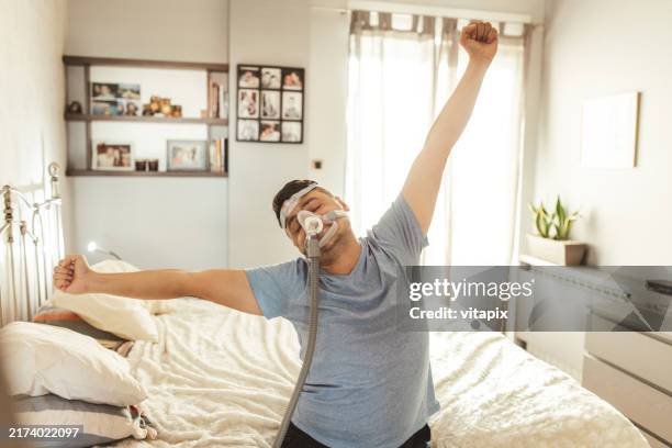 mann trägt cpap-gerät für schlafapnoe - schlafapnoe stock-fotos und bilder
