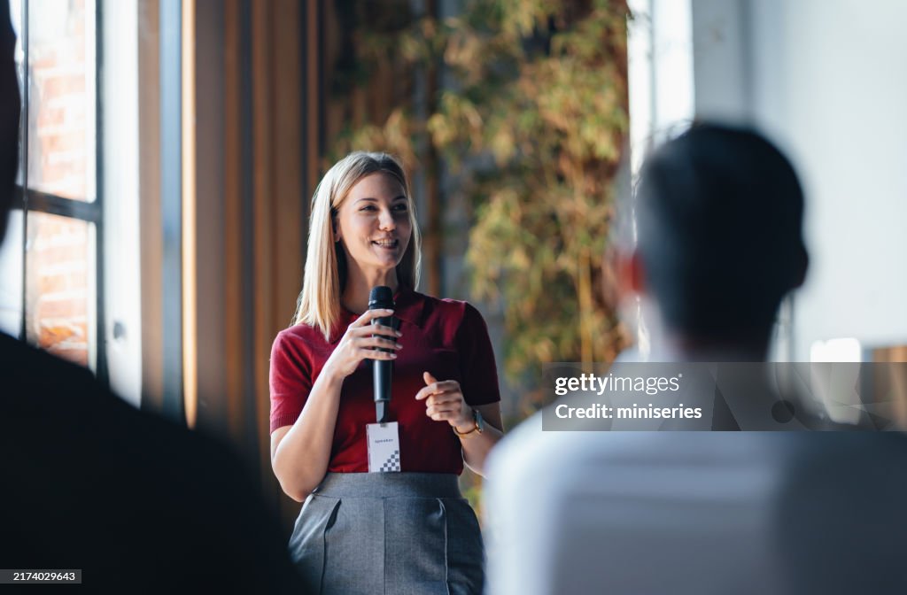 Confident Speaker Presenting to Engaged Audience at Business Event