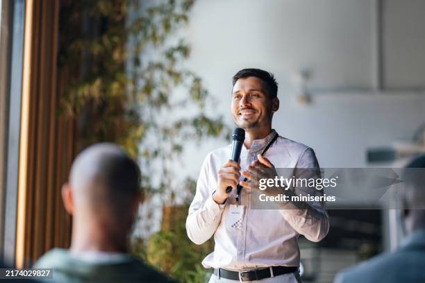 confident speaker engaging audience at business event - palestrante imagens e fotografias de stock