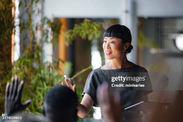 confident presenter leading business seminar with engaging speech - presenter stock pictures, royalty-free photos & images