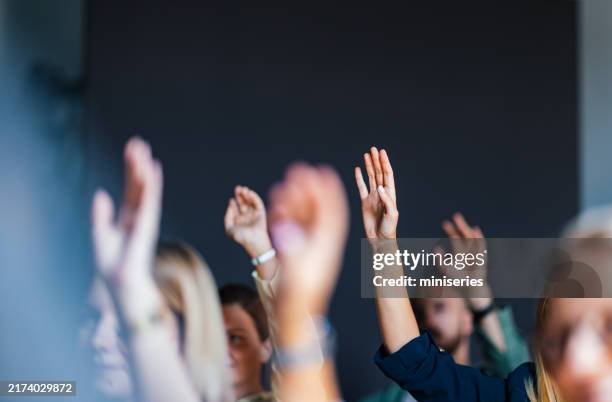 engaged audience raising hands at business event - asking stock pictures, royalty-free photos & images