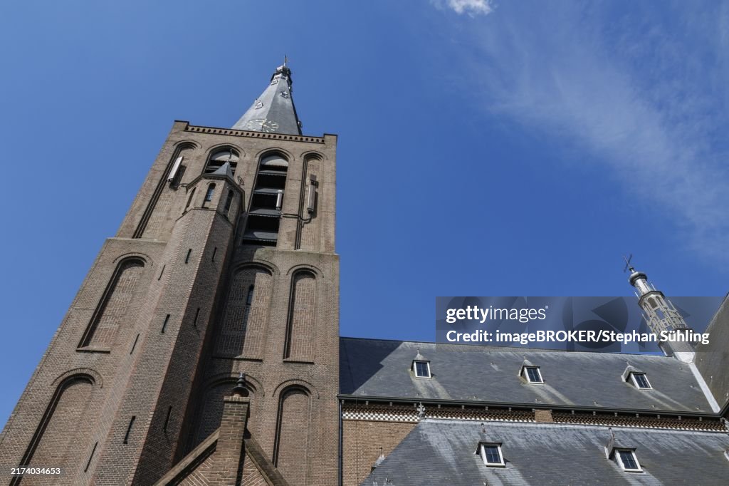 High gothic church building with towers, taken from below against a clear blue sky, aalten 2