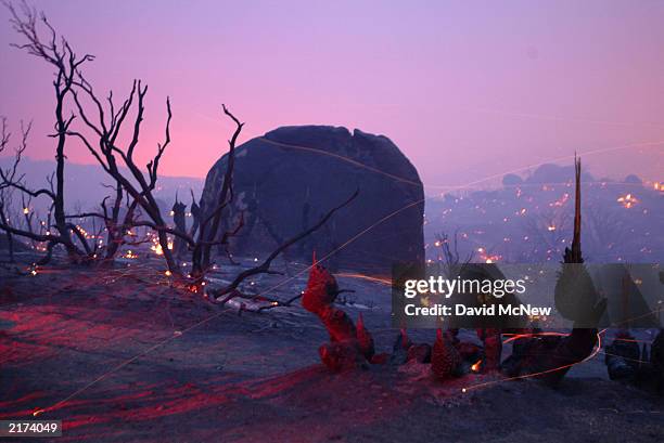 Embers blow across the burning landscape in Lost Valley as the Coyote Fire burns more than 11,000 acres of chaparral and forest on the night of July...