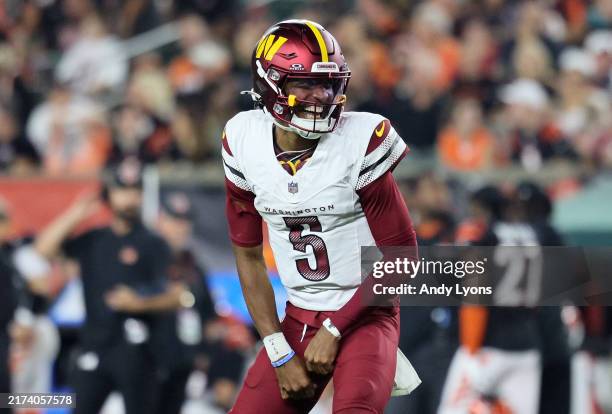 Jayden Daniels of the Washington Commanders celebrates a touchdown scored by Trent Scott against the Cincinnati Bengals during the third quarter at...