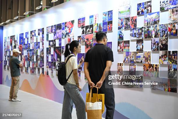 Visitors view a gallery wall during a special exhibition to mark the one year anniversary of the Hangzhou Asian Games on September 23, 2024 in...