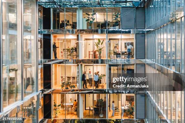 diverse professionals engage in a bustling multilevel office environment - stor grupp av människor bildbanksfoton och bilder