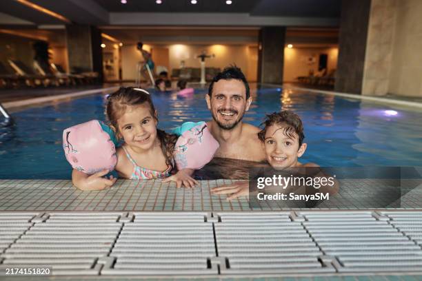 porträt einer familie im schwimmbad - hallenbad stock-fotos und bilder