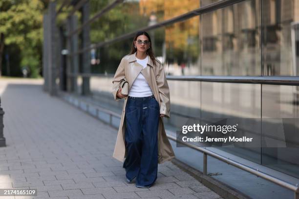 Anna Winter is seen wearing vintage sunglasses with rimless oval grey lenses, a silver metal nose bridge, and transparent temples featuring silver...
