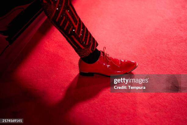 elegantes zapatos rojos de hombre pisan la alfombra roja al salir de la limusina. - oficio creativo fotografías e imágenes de stock