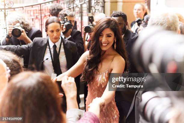 the actress arrives at the red carpet event and approaches her fans, taking a moment to sign autographs and share the excitement. - red carpet paparazzi stock pictures, royalty-free photos & images