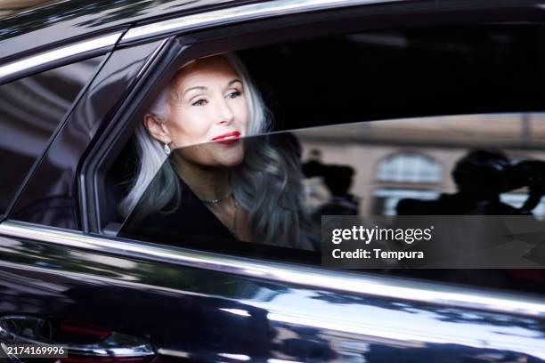 eager and full of expectations, the actress looks out the limousine window as she arrives at the red carpet event. - embaixador imagens e fotografias de stock