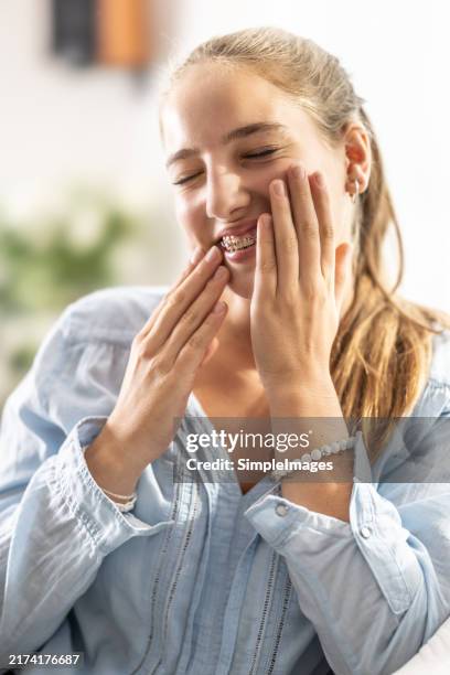 a young girl suffers from toothache due to braces. - sbiancamento dentale foto e immagini stock