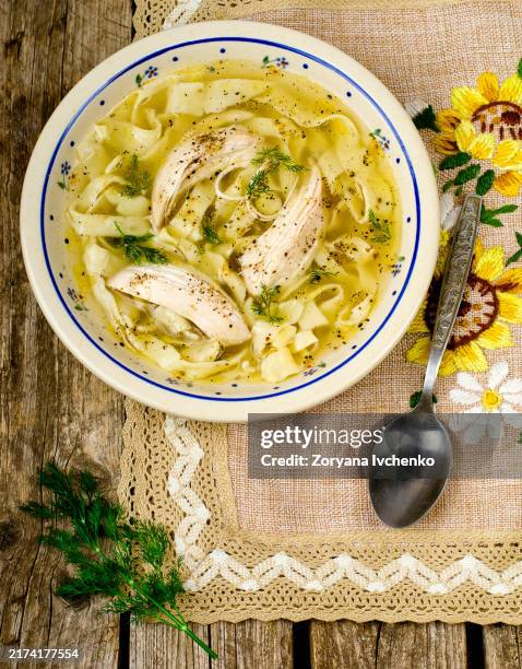 house chicken soup with handmade noodles on a wooden table - sopa de pollo con fideos fotografías e imágenes de stock
