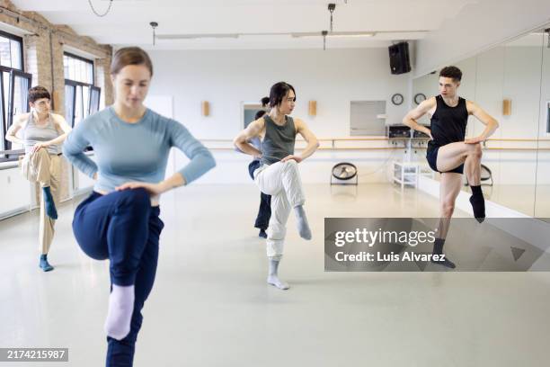 group of dancers in a studio refining contemporary techniques - hand on knee stock pictures, royalty-free photos & images