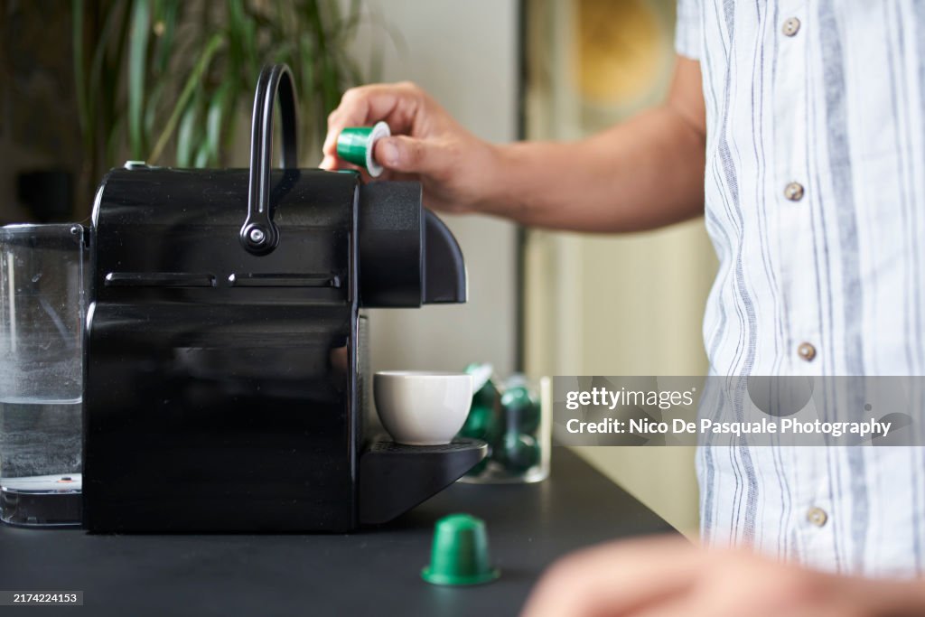 Man making an espresso with a capsules coffee maker