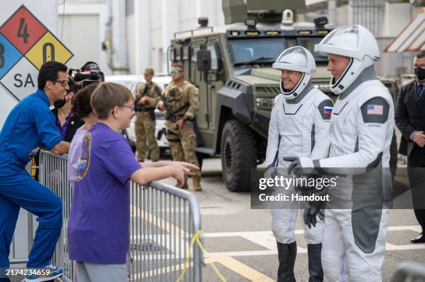 In this NASA handout, Roscosmos cosmonaut Aleksandr Gorbunov and NASA astronaut Nick Hague, wearing SpaceX spacesuits, speak with family and friends...