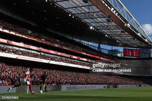 Arsenal's English midfielder Bukayo Saka takes a corner kick during the English Premier League football match between Arsenal and Leicester City at...