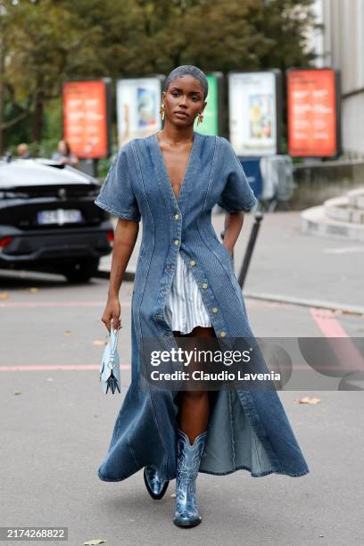 Guest wears denim short sleeves maxi dress, light blue striped mini skirt, metallic blue boots, outside Ganni, during Womenswear Spring/Summer 2025...