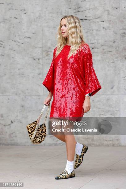 Guest wears red sequins mini dress, leopard print bag, leopard print loafers, white socks, outside Ganni, during Womenswear Spring/Summer 2025 as...