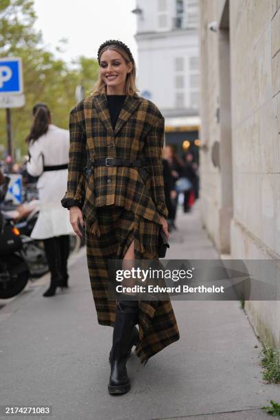 Olivia Palermo wears black yellow textured headband, black shirt, black yellow plaid pattern/print oversized distressed scarf Dior blazer jacket,...