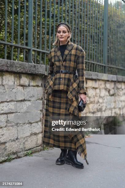 Olivia Palermo wears black yellow textured headband, black shirt, black yellow plaid pattern/print oversized distressed scarf Dior blazer jacket,...