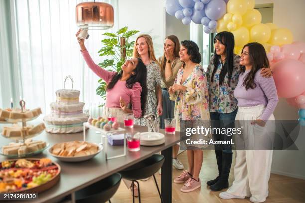 diverse group's polaroid selfie at festive baby shower - mom taking photos of baby eating imagens e fotografias de stock