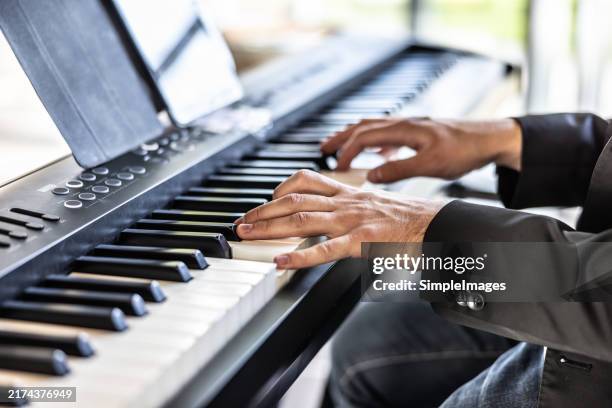 hands of a musician playing the piano somewhere at a concert or wedding - synthesizer stock pictures, royalty-free photos & images