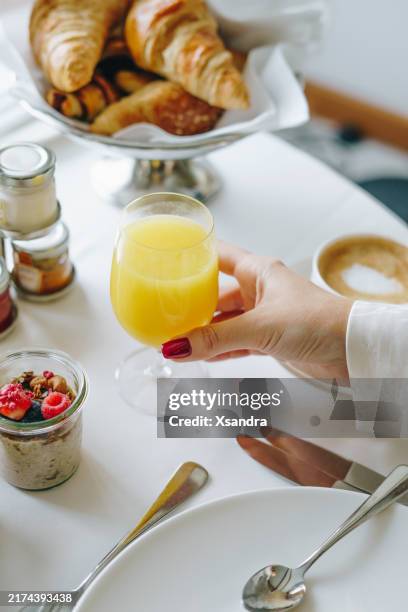 mujer tomando un desayuno relajante con café, cruasanes y fruta fresca - brunch fotografías e imágenes de stock