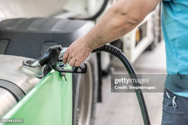 a man fills a truck with diesel fuel - diesel fuel stock pictures, royalty-free photos & images