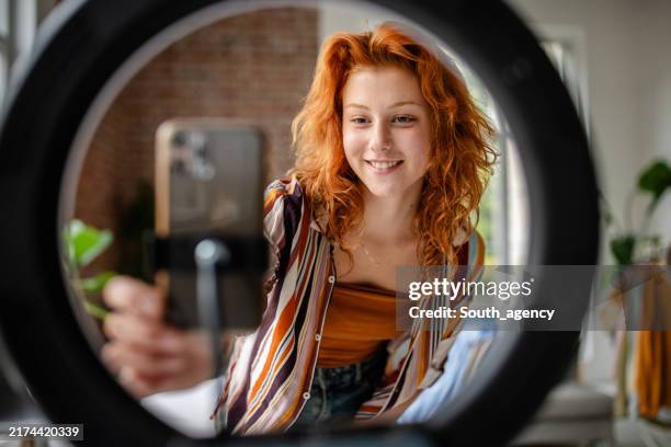 person adjusts camera setup in front of ring light. - user generated content stock pictures, royalty-free photos & images