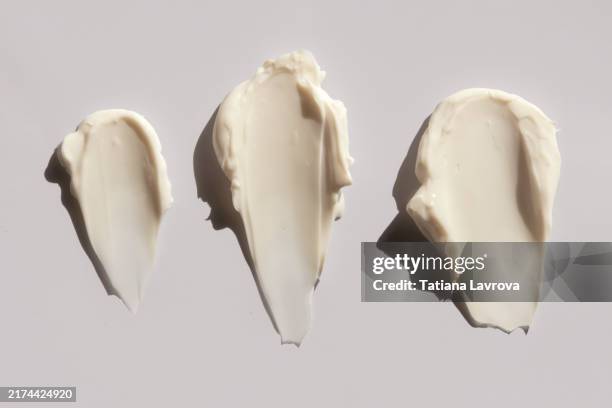 set of different shaped body, face and hands moisturizing cream swatches isolated on light gray background. - farbprobe stock-fotos und bilder