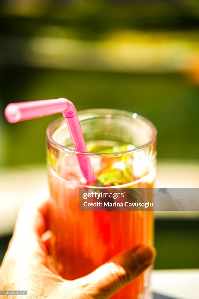 Colorful summer mocktail in hand.