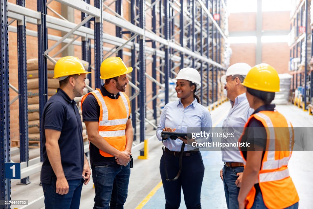 Female boss giving instructions to employees at a distribution warehouse