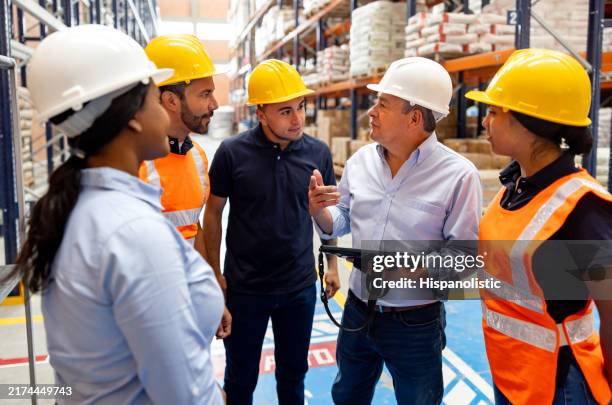 foreperson giving instructions to employees at a distribution warehouse - pep talk stock pictures, royalty-free photos & images