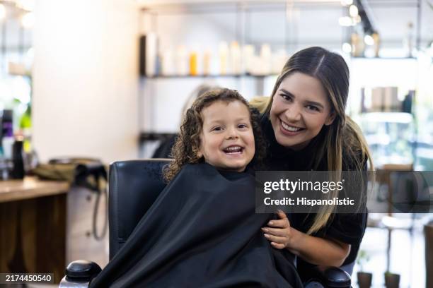happy boy getting a haircut at the hairdressers and smiling - klippa håret bildbanksfoton och bilder