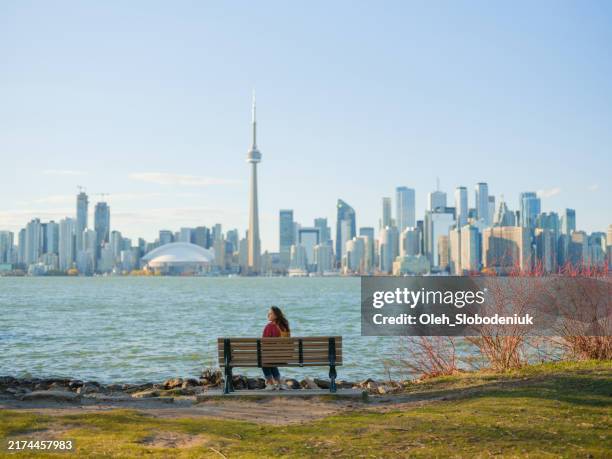 woman looking at cityscape from toronto island - great lakes stock pictures, royalty-free photos & images