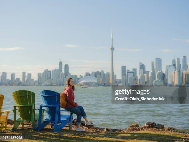 femme regardant le paysage urbain de toronto depuis le parc de l’île de toronto - toronto photos et images de collection